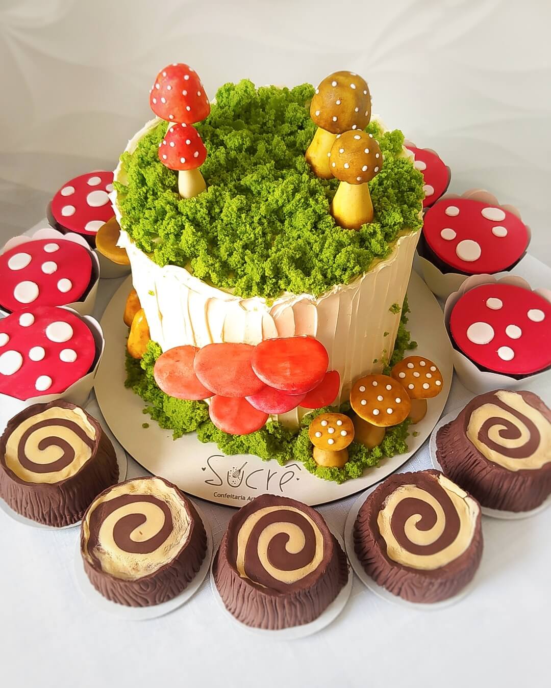Bolo, alfajores e cupcakes decorados no tema cogumelos