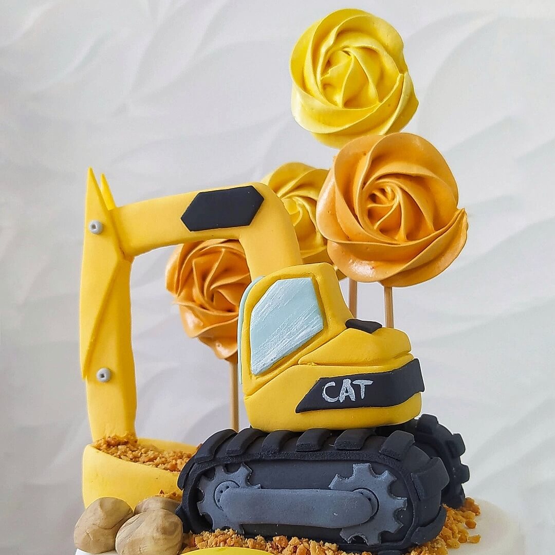 Bolo decorado com retroescavadeira modelada e pirulitos de marshmallow