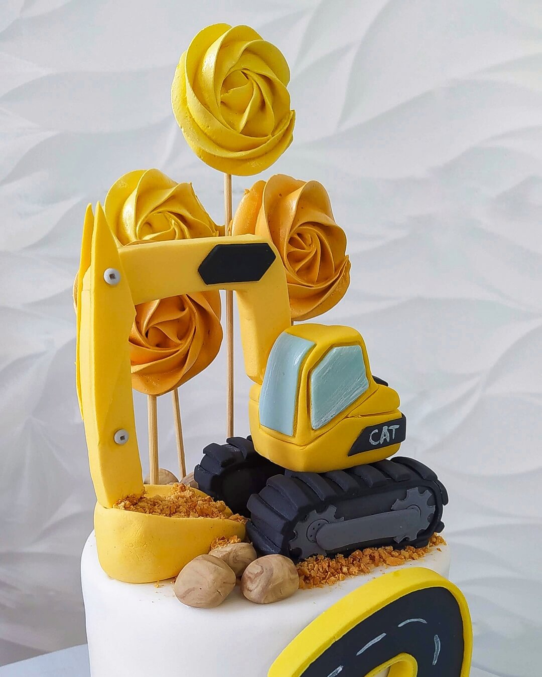 Bolo decorado com retroescavadeira modelada e pirulitos de marshmallow